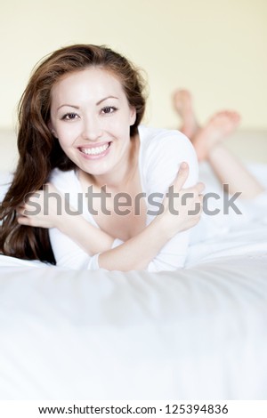 Attractive Asian Mixed Woman in Bed Smiling happily
