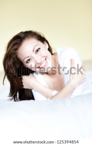 Attractive Asian Mixed Woman in Bed Smiling happily with head tilted