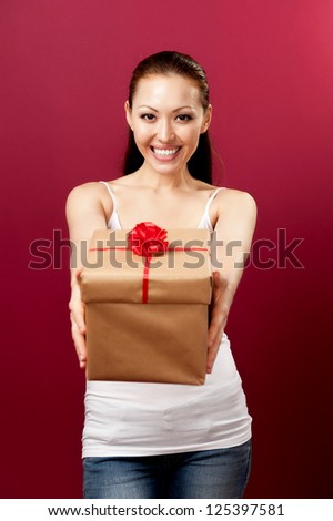 Attractive Asian Mixed Woman presenting gift with a sweet smile