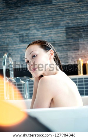 Attractive Mixed Asian Female having a bath with candles