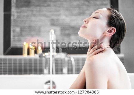 Attractive Mixed Asian Female touching neck in the bath