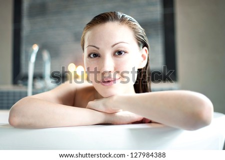 Attractive Mixed Asian Female having a bath looking at the camera