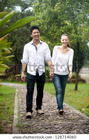 Attractive Asian Couple smiling on a date in the park