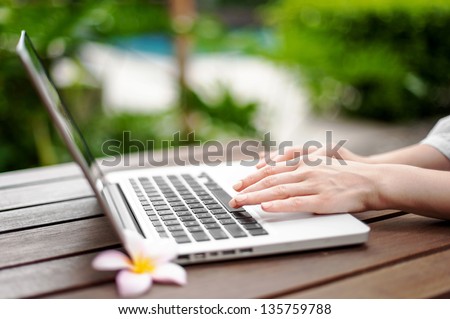 Hands using the laptop with a flower