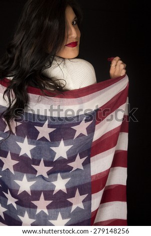 Woman holding American flag looking over shoulder