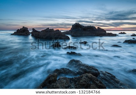 Rocky coastal seascape. This is a long exposure image of a rocky coastal scene taken just after sunset.  This photo was taken at Corona del Mar, Newport Beach, California.