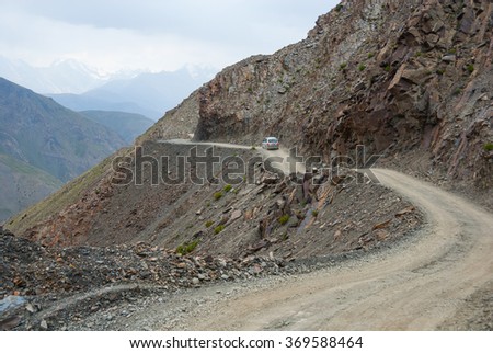 Small car on the steep and shallow dangerous mountain road