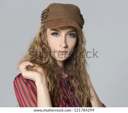 portrait of beautiful blond girl with curly hair in cap