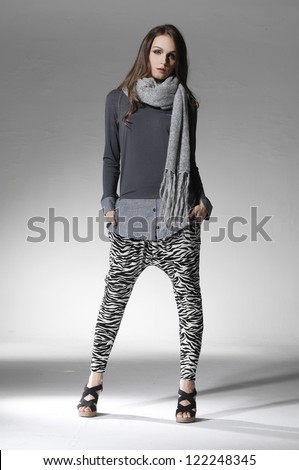 Full body beautiful casual young woman in scarf standing isolated against white background