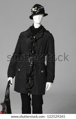 Black coat with handbag in hat on female a mannequin