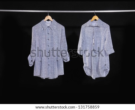 Two woman clothes on a hanger studio isolated on black