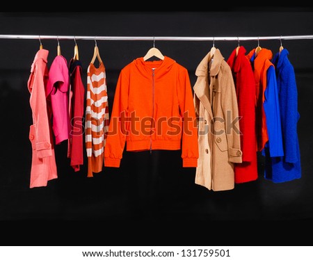 female colorful fashion clothing on hangers- black background