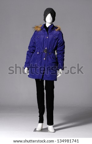 Full-length female clothing in hat with blue coat on mannequin