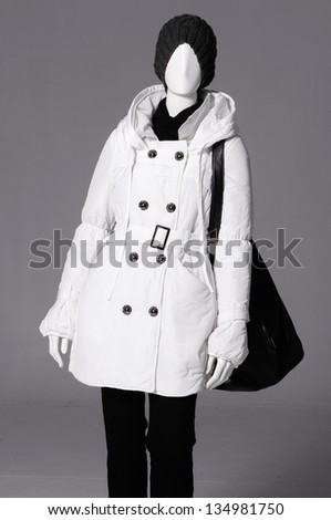 female clothing in white coat with bag on mannequin