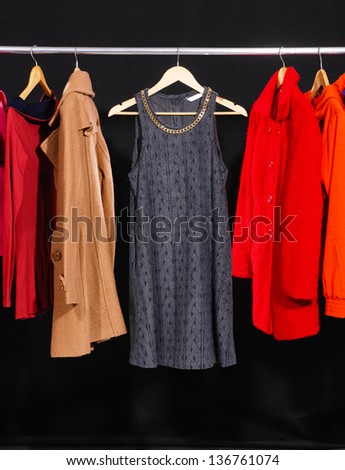female colorful fashion clothing on hangers- black background