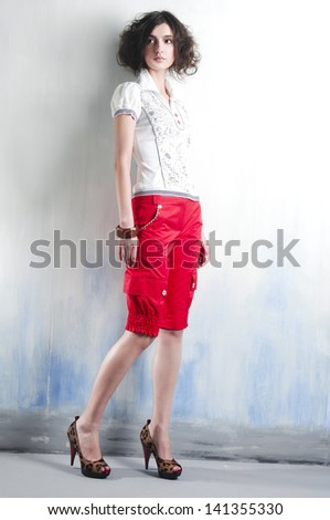 Full length young woman standing posing in studio
