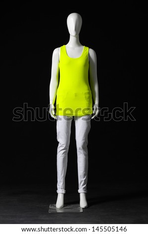 Mannequin dressed in green t-shirt and trousers on black