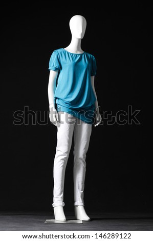 full-length mannequin dressed in blue dress and trousers on black background