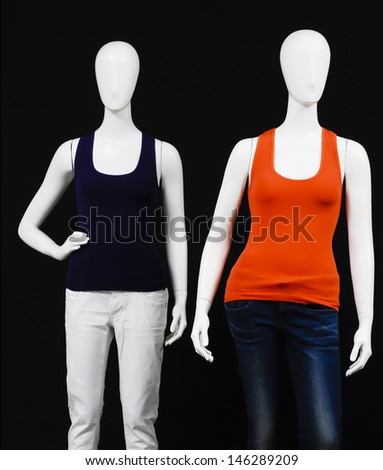 Two mannequin dressed in red and black l shirt and trousers on black background