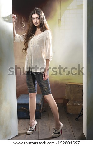full length Slim pretty young girl posing on wooden floor in light background