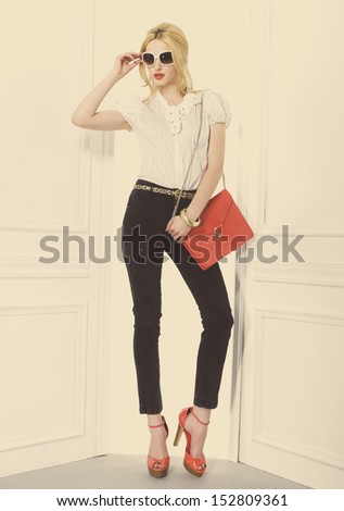 Full Body Portrait Of Beautiful Blonde Girl Holding Red Bag Posing In Studio