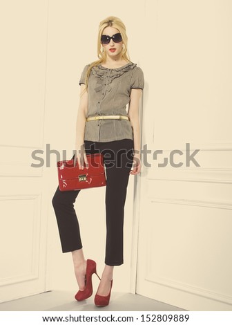Full body Portrait of beautiful blonde girl holding purse posing