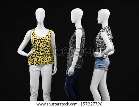 Three mannequin dressed in shirt and trousers-black background