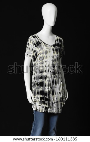 mannequin dressed in shirt and trousers on black background