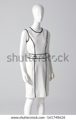 Mannequin dressed in white evening gown on gray background