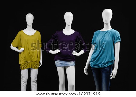 Three mannequin dressed in shirt and trousers on black background
