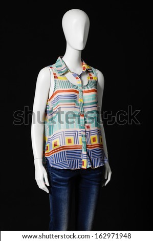 mannequin dressed in colorful shirt and jeans on black background