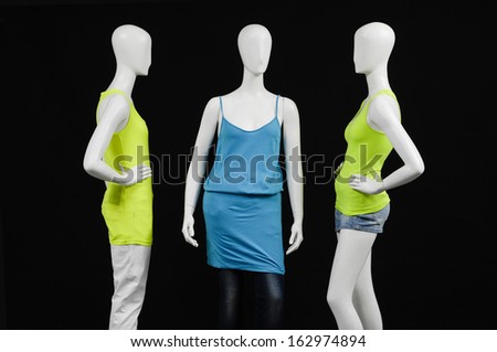three mannequin female dressed in fashion shirt and trousers on black background