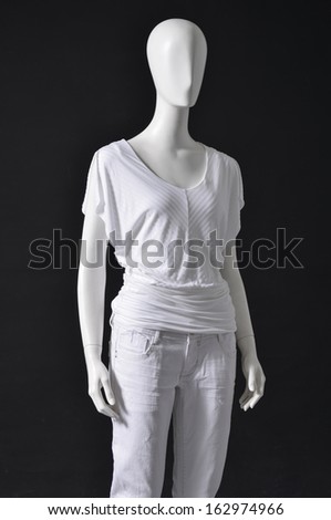 mannequin female dressed in shirt and white trousers-black background