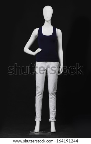 full-length mannequin female dressed in black shirt and white trousers on black background
