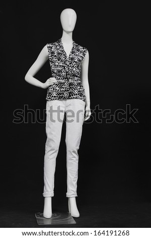 full-length mannequin female dressed in shirt and white trousers on black background