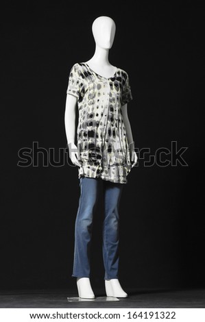 full-length female mannequin dressed in jeans on black background