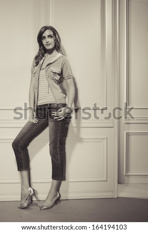 Full length young fashion model posing standing and looking in camera-black and white