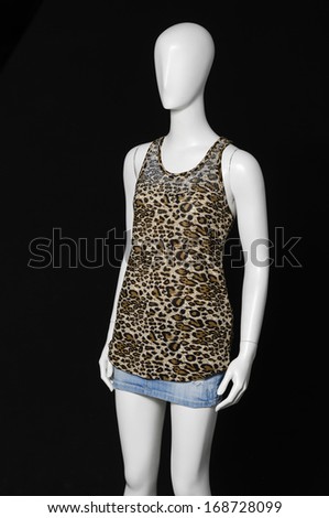 female mannequin in shirt and jeans shorts-black background