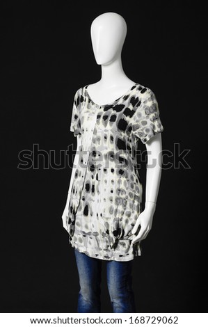 mannequin female dressed in gray shirt and jeans on black background