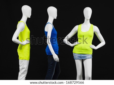 Three mannequin female yellow and blue shirt dress on black background