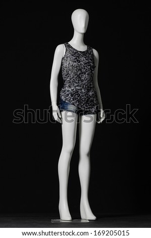 full-length female mannequin in gray dress and shorts on black background