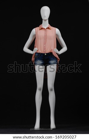 full-length female mannequin in shirt dress and shorts on black background