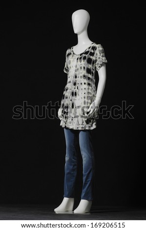 full-length mannequin female dressed in gray shirt and jeans on black background