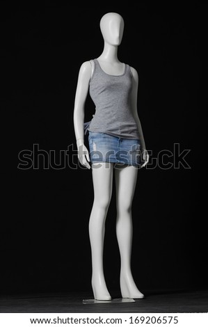 mannequin female dressed in gray shirt and short on black background