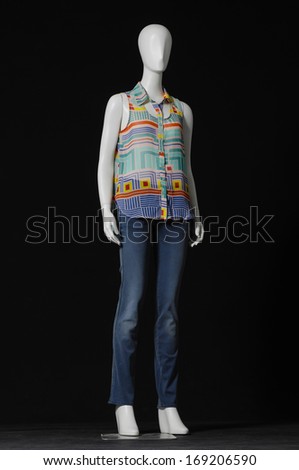 full-length mannequin dressed in colorful shirt and jeans on black background