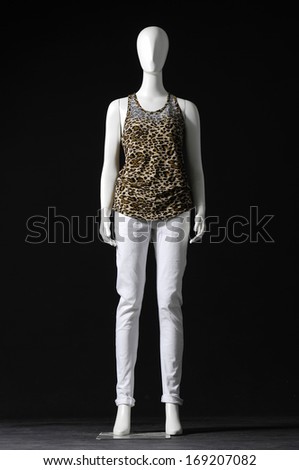 full-length mannequin female dressed in shirt and white trousers on black background