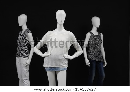 Three mannequin dressed in fashion shirt and trousers on black background