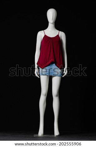 full-length mannequin female dressed in red shirt and short on black background