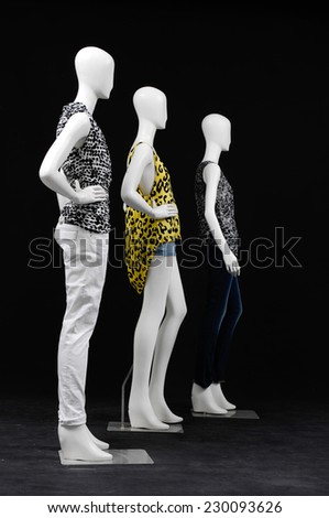 Three mannequin dressed in fashion shirt and trousers on black background