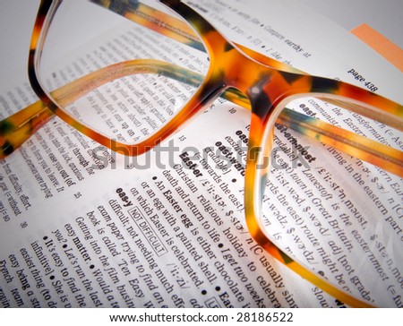 Dictionary page closeup with the word Easter and brown glasses on it